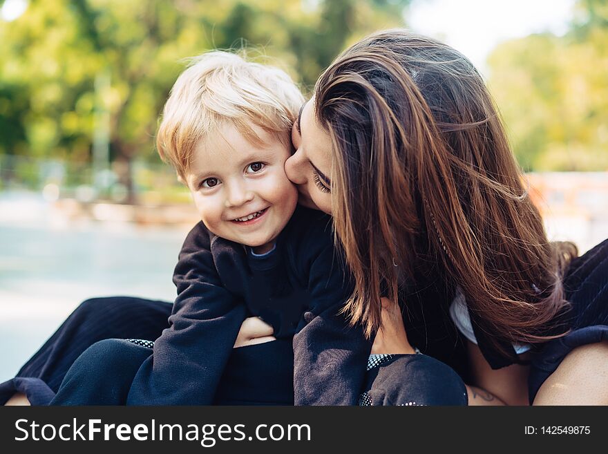 Young mother is playing with her child outside in the park