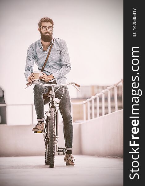 Hipster posing on his bike in a balcony