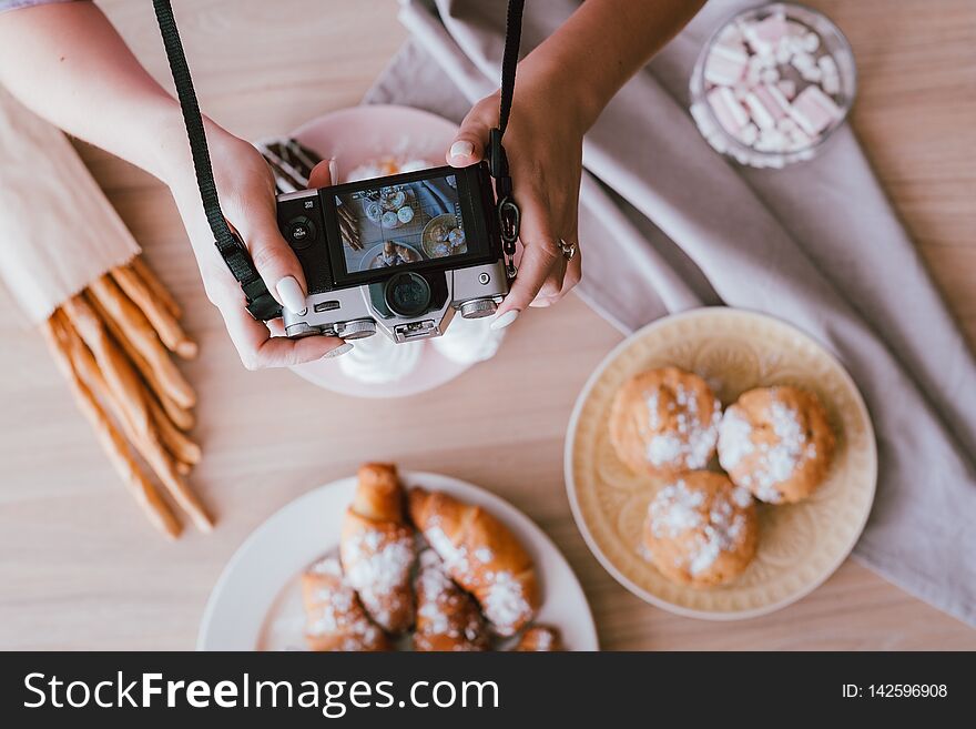 Food blogging hobby. Sweet homemade bakery assortment. Woman shooting fresh cakes and pastries from above. Food blogging hobby. Sweet homemade bakery assortment. Woman shooting fresh cakes and pastries from above.