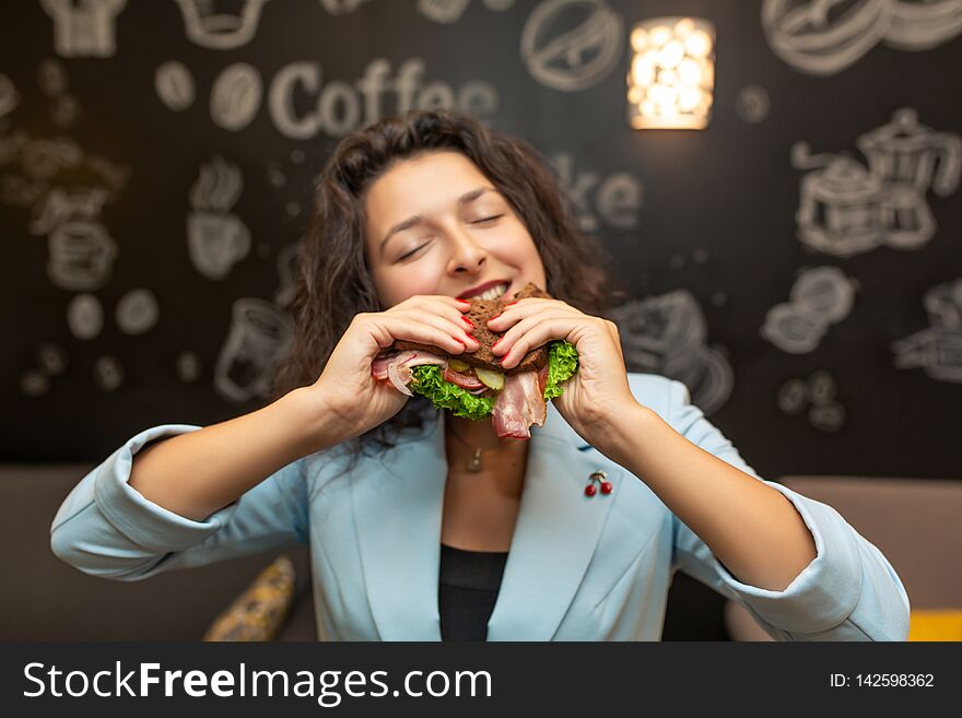 Closeup portrait of hungry young caucasian woman, bite sandwich