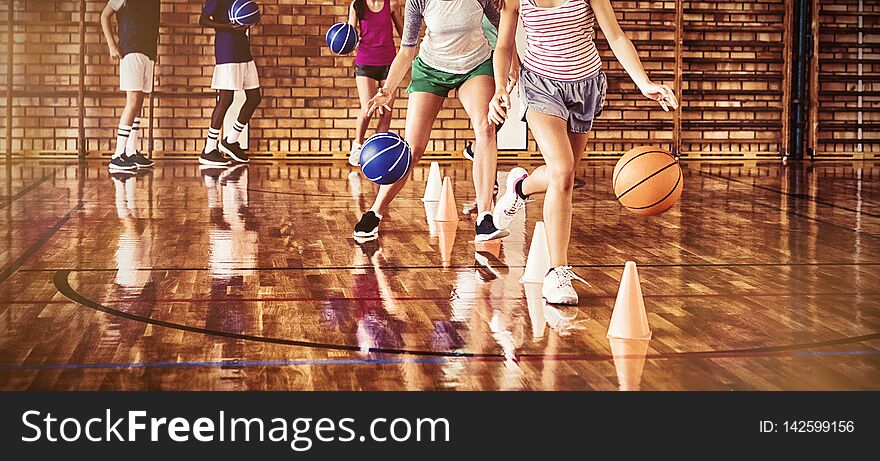 High school kids practicing football using cones for dribbling drill