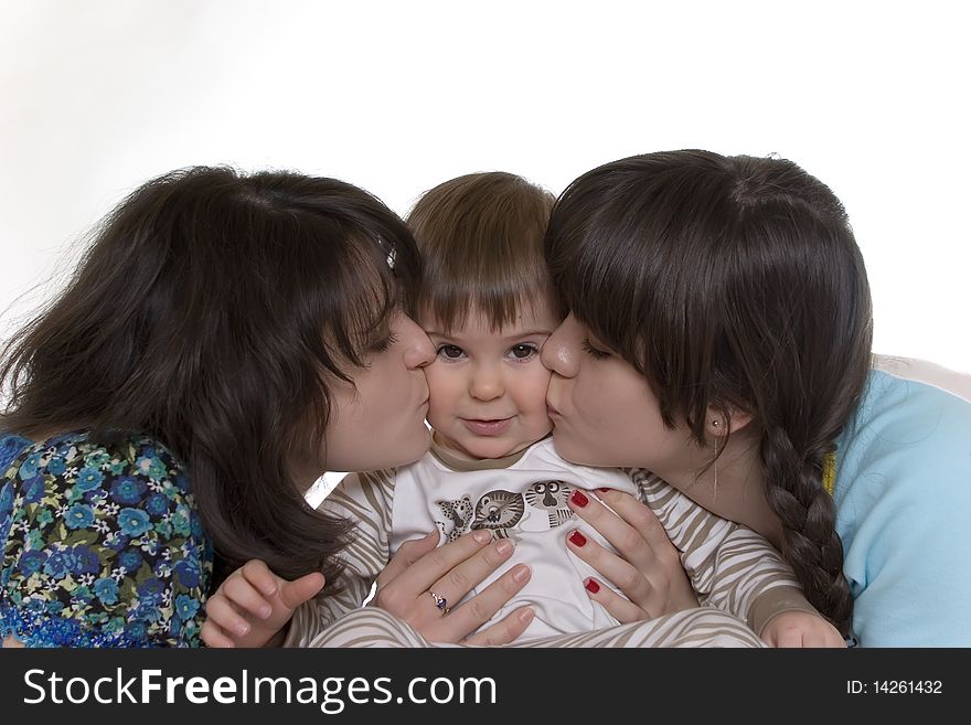 Two girls kissing baby on both cheeks