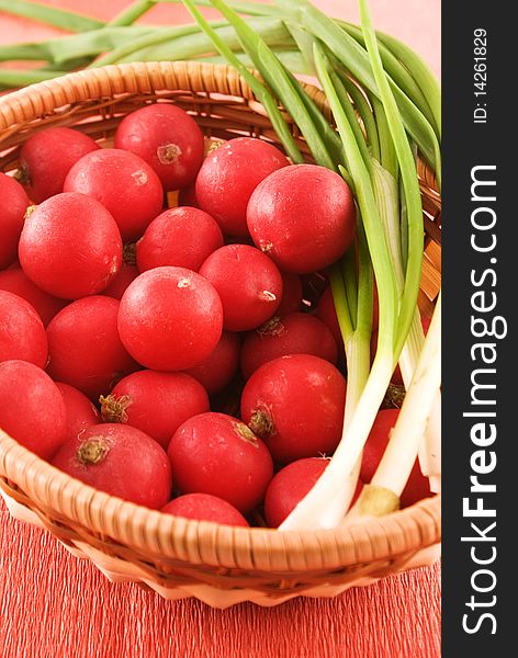 Full wicker basket with fresh radish and onion