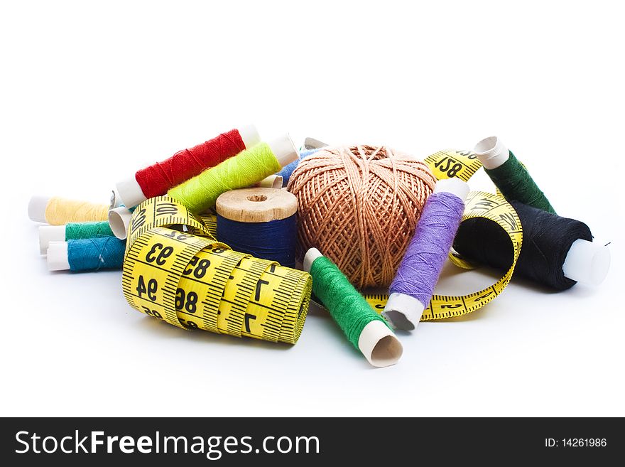 Colorful thread with yellow measuring tape isolated on white. Colorful thread with yellow measuring tape isolated on white