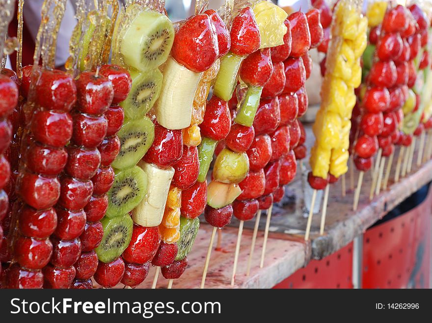 This image is of fruits on a stick. They are soaked in a sweet candy. The candy then hardens into a shell covering the fruit. Very sweet tasting. This image is of fruits on a stick. They are soaked in a sweet candy. The candy then hardens into a shell covering the fruit. Very sweet tasting.