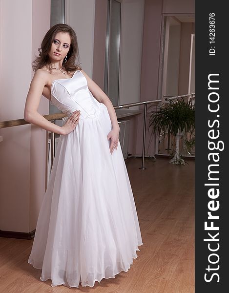 Girl in white wedding dress in dance studio. Girl in white wedding dress in dance studio