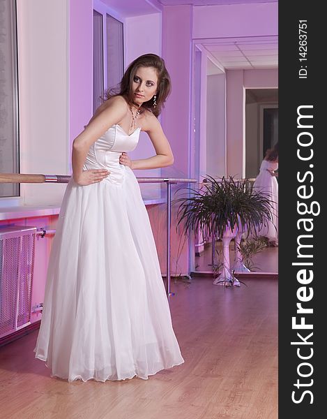 Girl in white wedding dress in dance studio. Girl in white wedding dress in dance studio