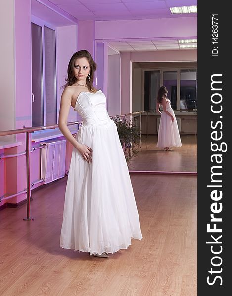 Girl in white wedding dress in dance studio. Girl in white wedding dress in dance studio