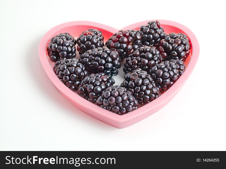 Pink heart shape filled with blackberries. Pink heart shape filled with blackberries.