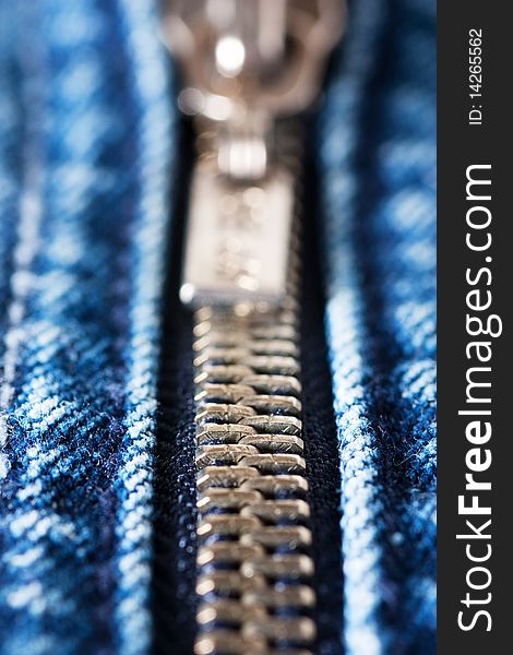 Macro shot of closed zipper on a blue jeans. Shallow depth of field