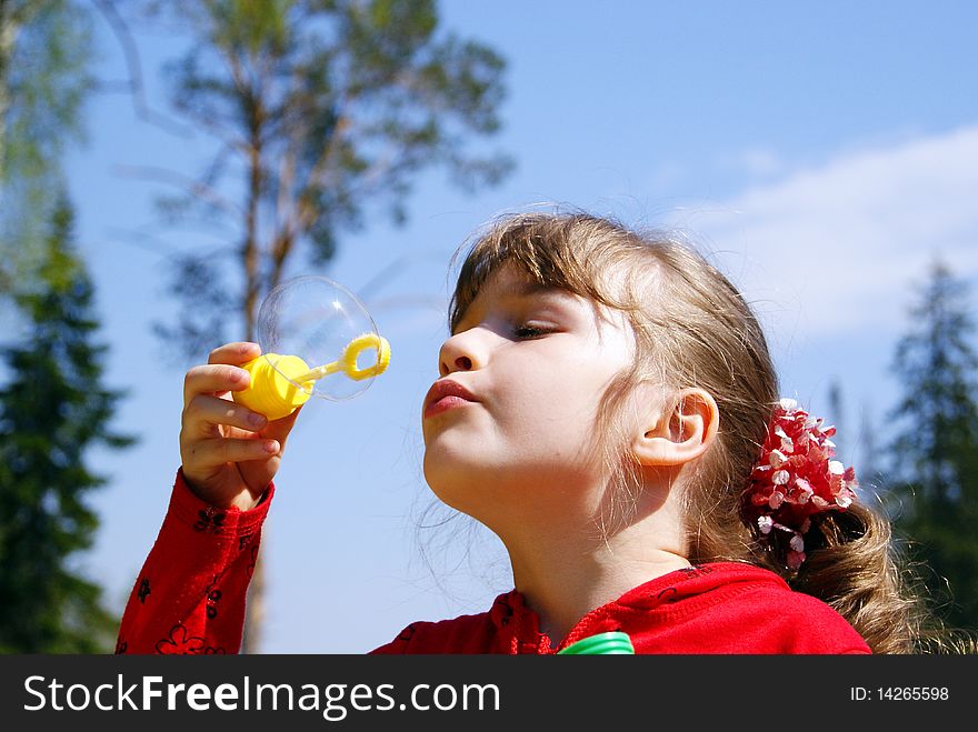 In the summer on the nature the girl inflates a soap bubble. In the summer on the nature the girl inflates a soap bubble