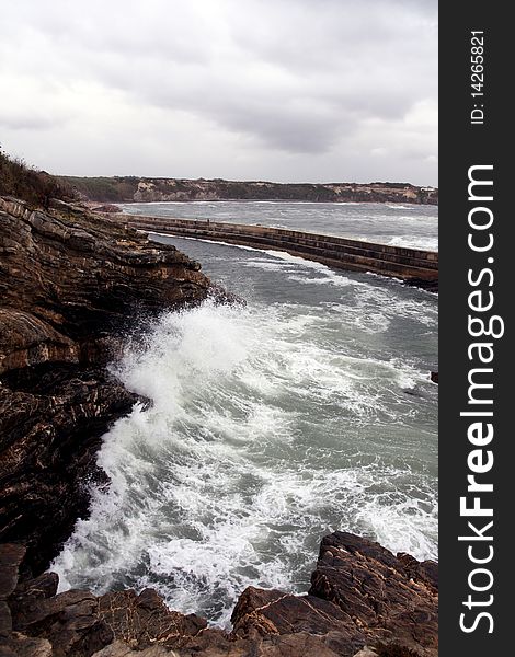 View of a furious wave hitting the cliffs on the coastline of Alentejo, Portugal. View of a furious wave hitting the cliffs on the coastline of Alentejo, Portugal.