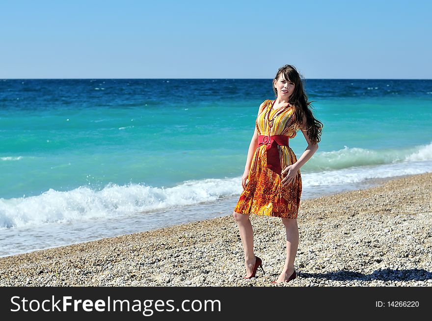 Longhaired pretty woman in orange on the beach. Longhaired pretty woman in orange on the beach