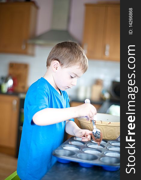 Young boy making chocolate cakes