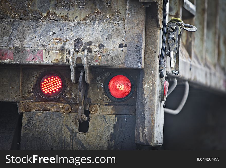 Red tail lights of a dump truck coming to a stop on the road. Red tail lights of a dump truck coming to a stop on the road