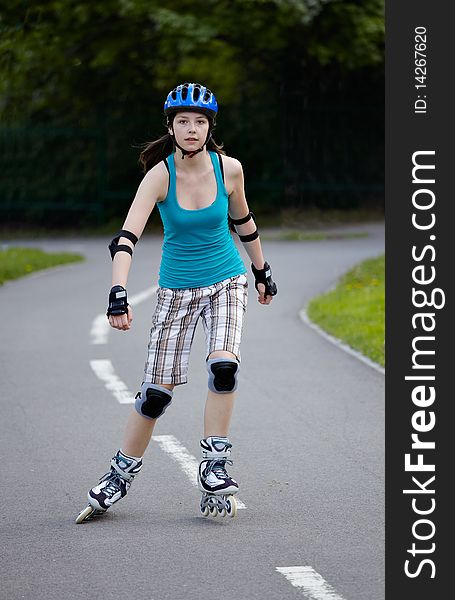 Young girl is rollerblading in the park. Young girl is rollerblading in the park.