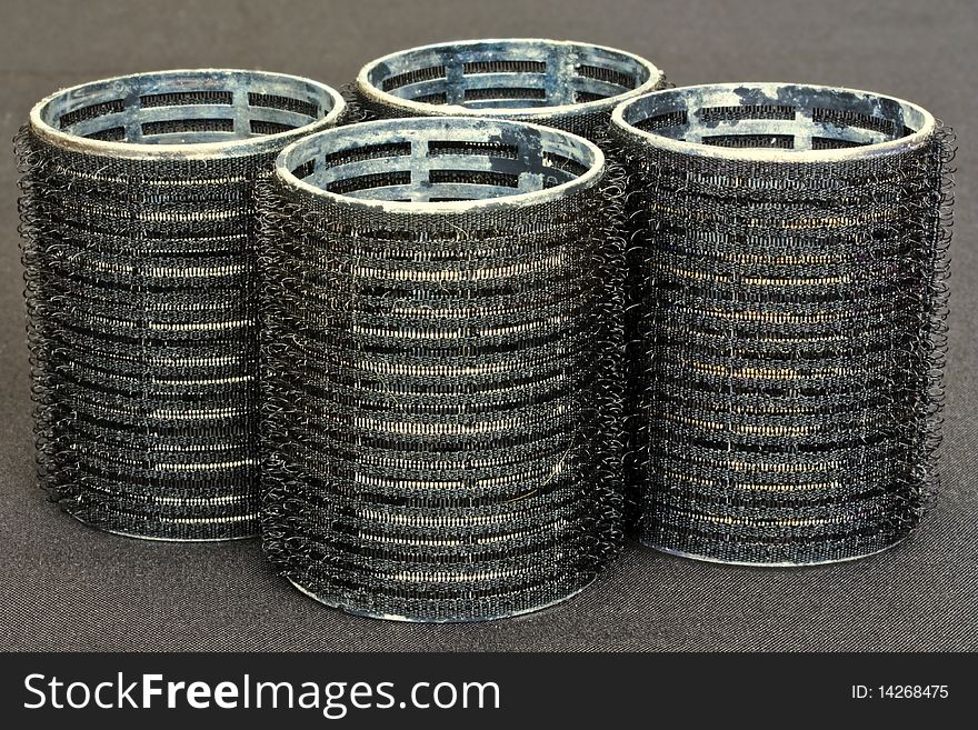 plastic hair rollers against a black background