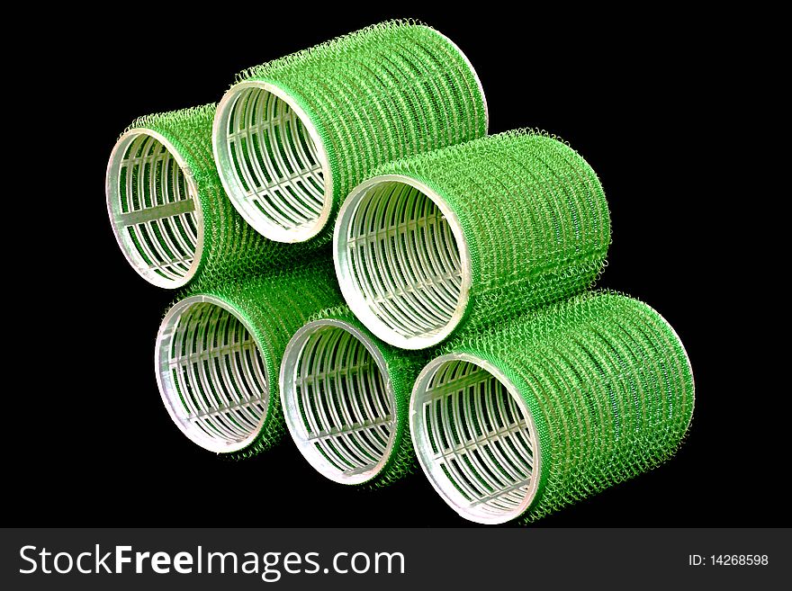 plastic hair rollers against a black background