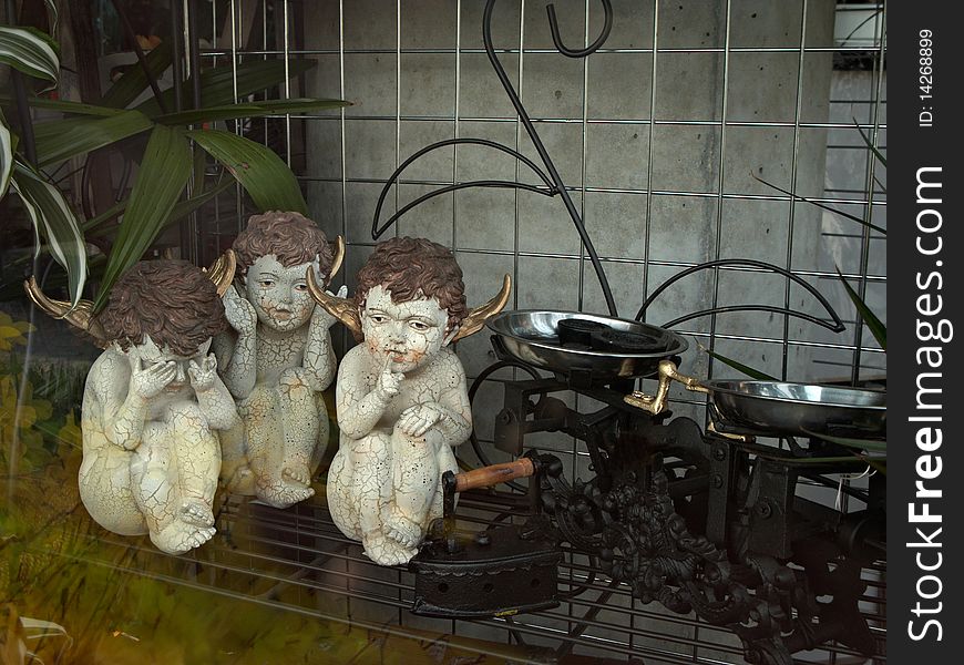 Three porcelain angels in a shop-window. Three porcelain angels in a shop-window.