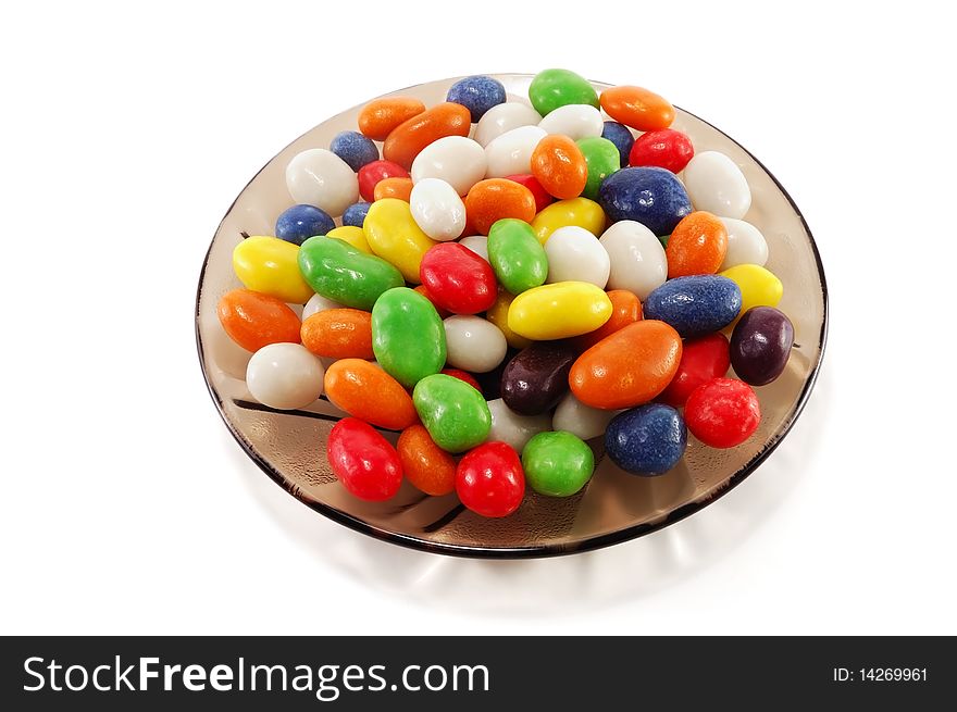 Multicolored candy on a plate isolated on a white background
