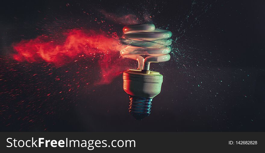 Studio photography of the real explosion of a low-consumption light bulb shot at the exact moment of the impact with a bullet. Gases and glasses are visible when moving. . Concept of obsolescence
