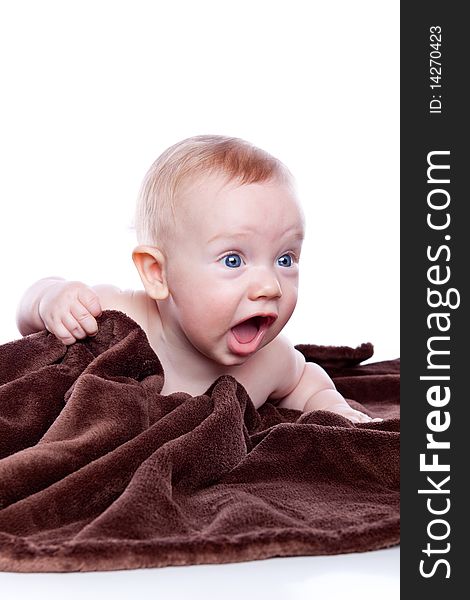 Beautiful baby under a brown towel on white background