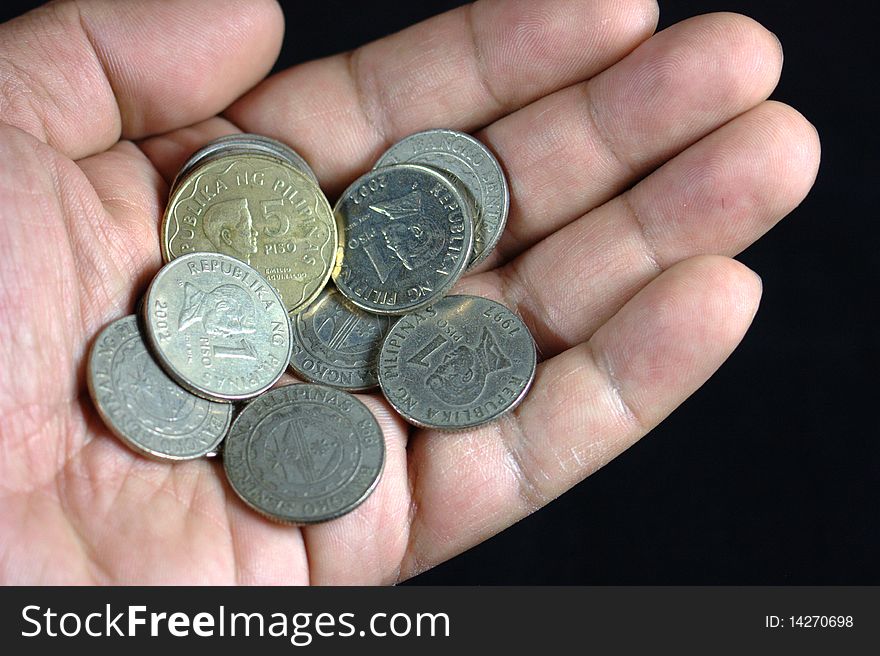 Coins in a hand with black background. Coins in a hand with black background