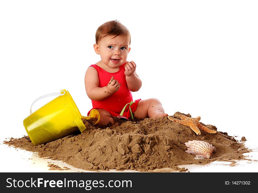 A baby girl with sand toys and shells making faces after tasting the sand she's sitting in. Isolated on white. A baby girl with sand toys and shells making faces after tasting the sand she's sitting in. Isolated on white.