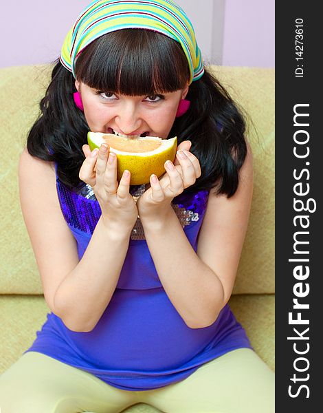 Pregnant woman eating fruits at home