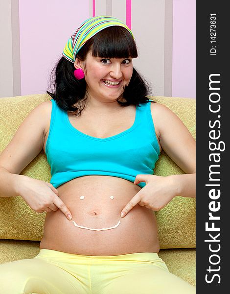 Pregnant female on yellow sofa