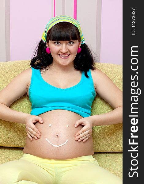 Pregnant female on yellow sofa