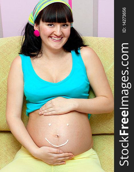 Pregnant female on yellow sofa