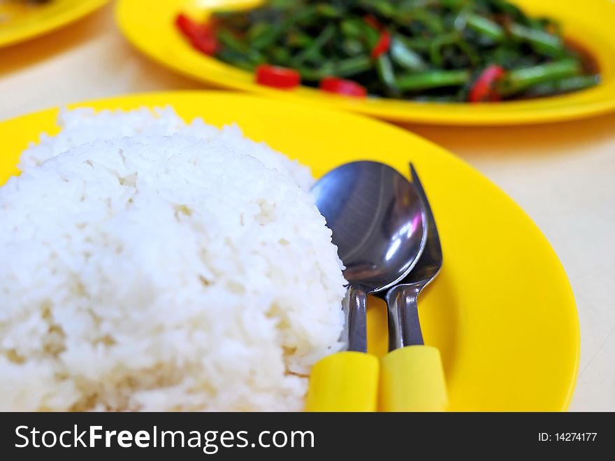 White rice with vegetable dishes in background. Rice is the stable diet in most Asian countries. For diet and nutrition, healthy eating and lifestyle concepts. White rice with vegetable dishes in background. Rice is the stable diet in most Asian countries. For diet and nutrition, healthy eating and lifestyle concepts.