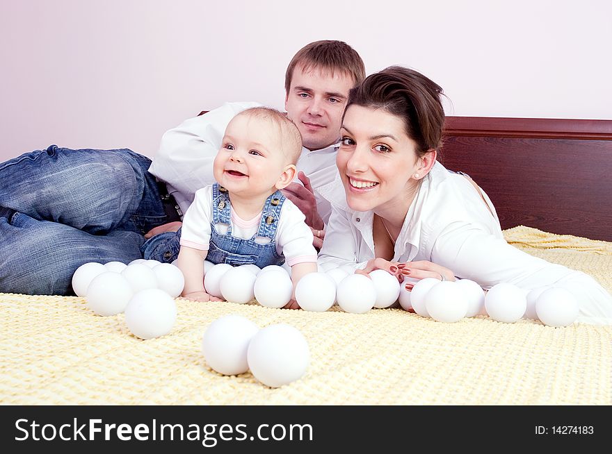 Happy family plays on the bed
