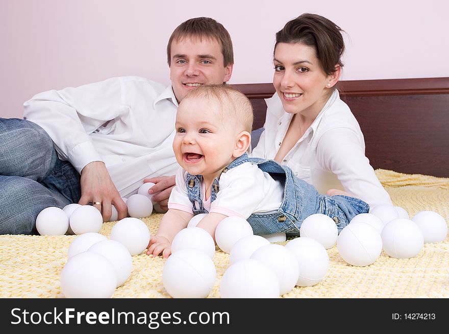 Happy family plays on the bed