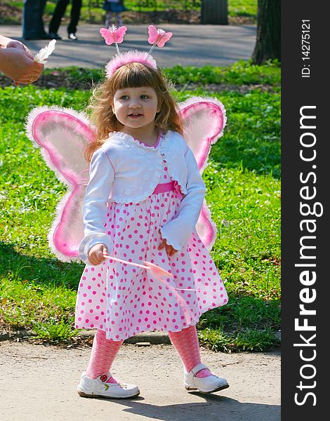 Young girl with wings in park