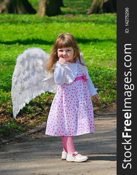 Young girl with wings in park