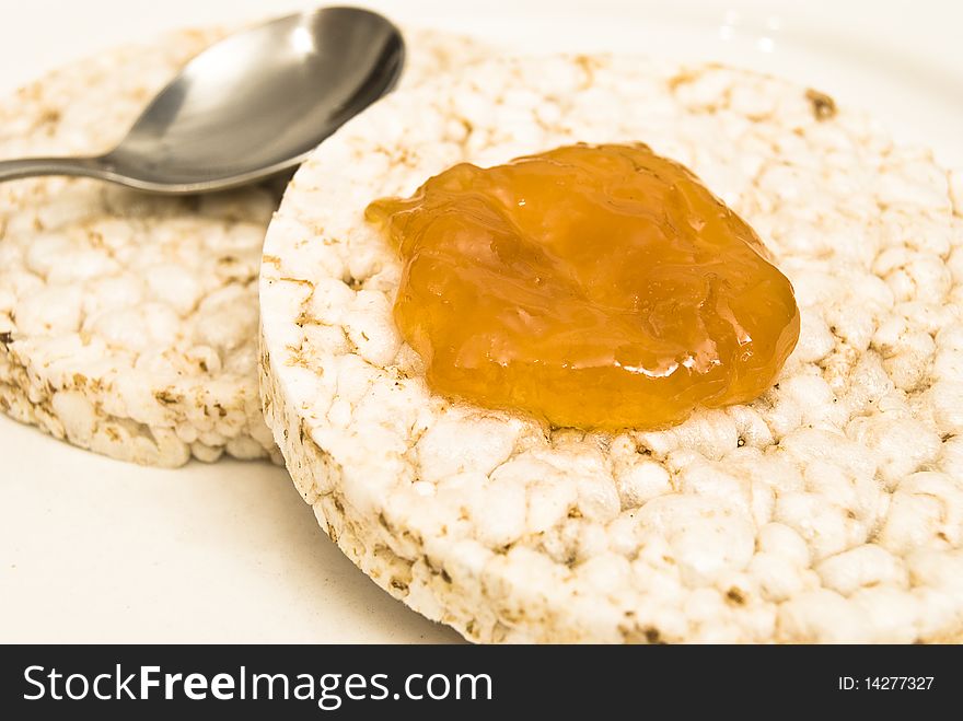 Rice biscuits with apricot jam and a spoon