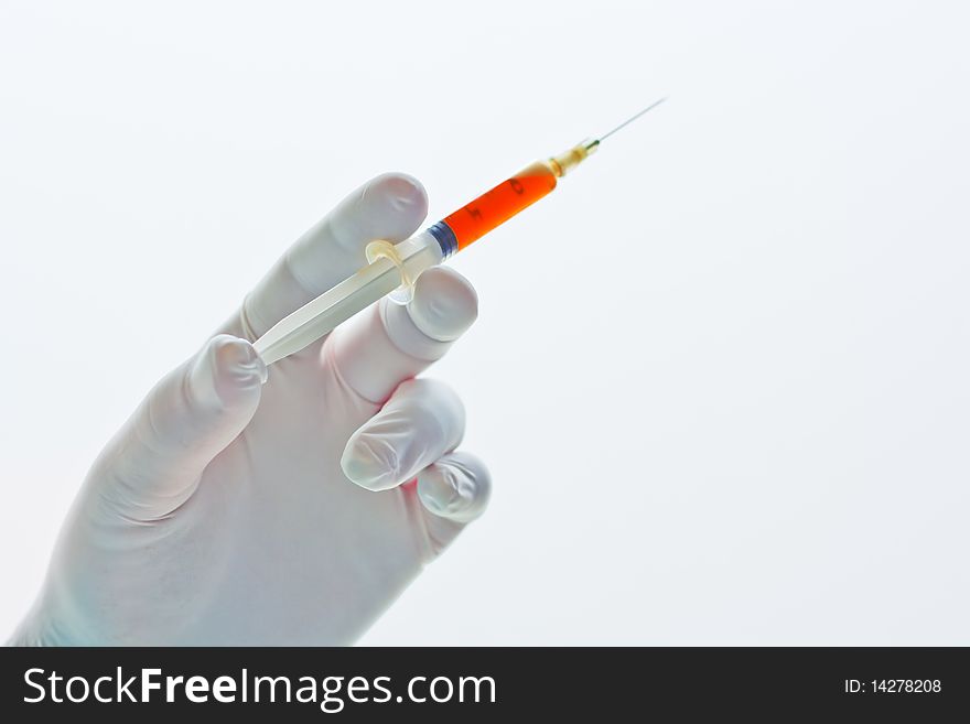 Hand holding a syringe filled with red liquid or blood isolated on white background