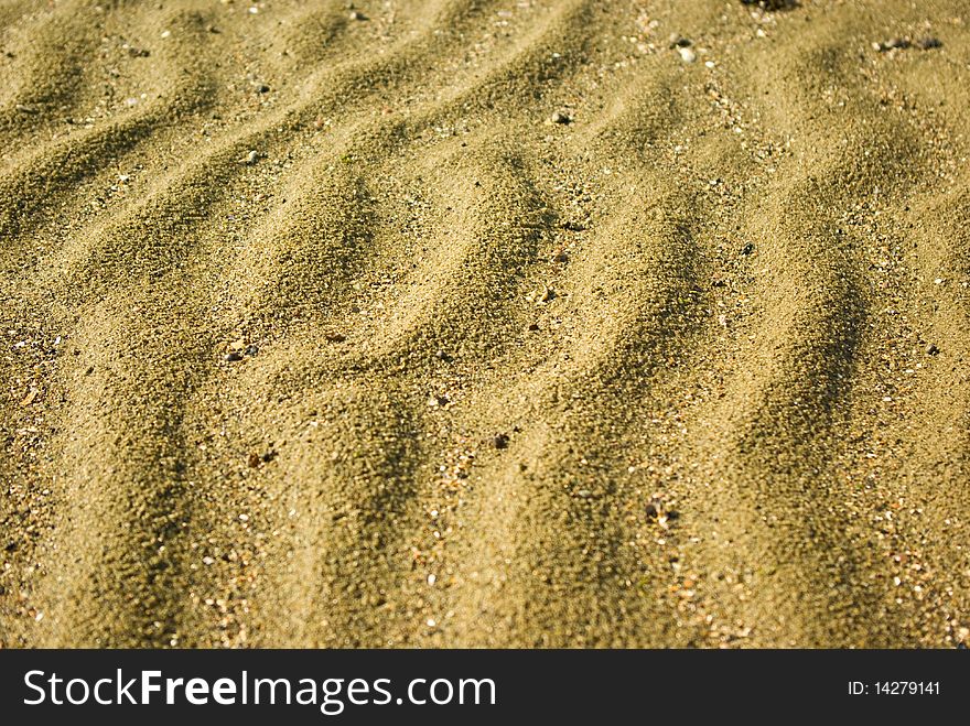 Sand background with little stones, close up