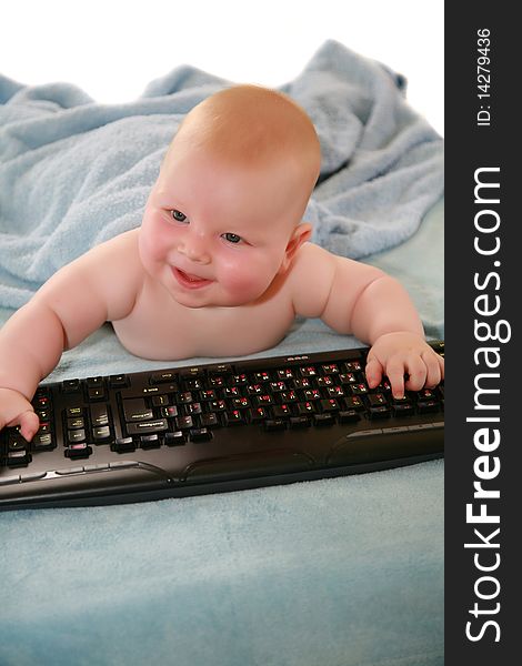 Blonde boy with blue eyes and rosy cheeks, played on a black keyboard and looks at the camera. Blonde boy with blue eyes and rosy cheeks, played on a black keyboard and looks at the camera