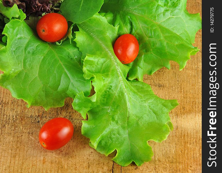 Lettuce and Tomatoes in Colander on Wood