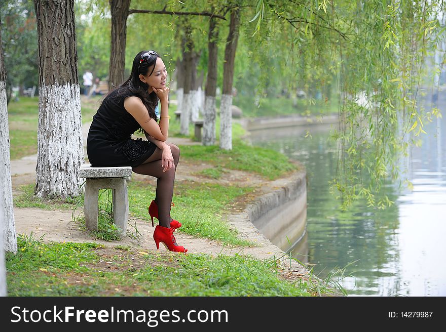 Asian woman sit in Chair with  High-heeled shoes.