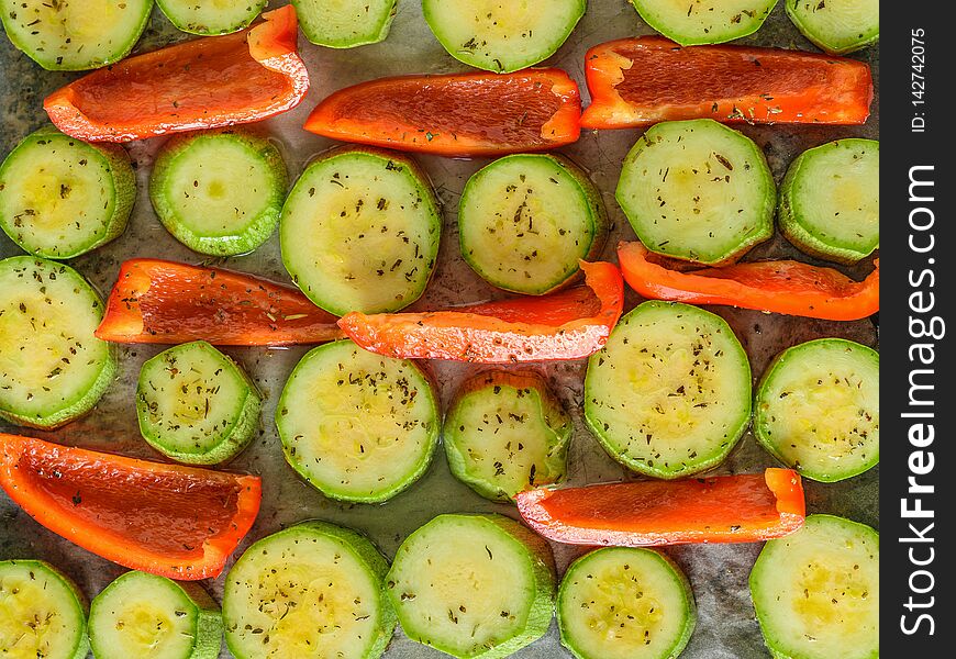 Vegetables with spices and herbs in oil on the baking sheet. Vegetarian dish. The view from the top. Flat lay