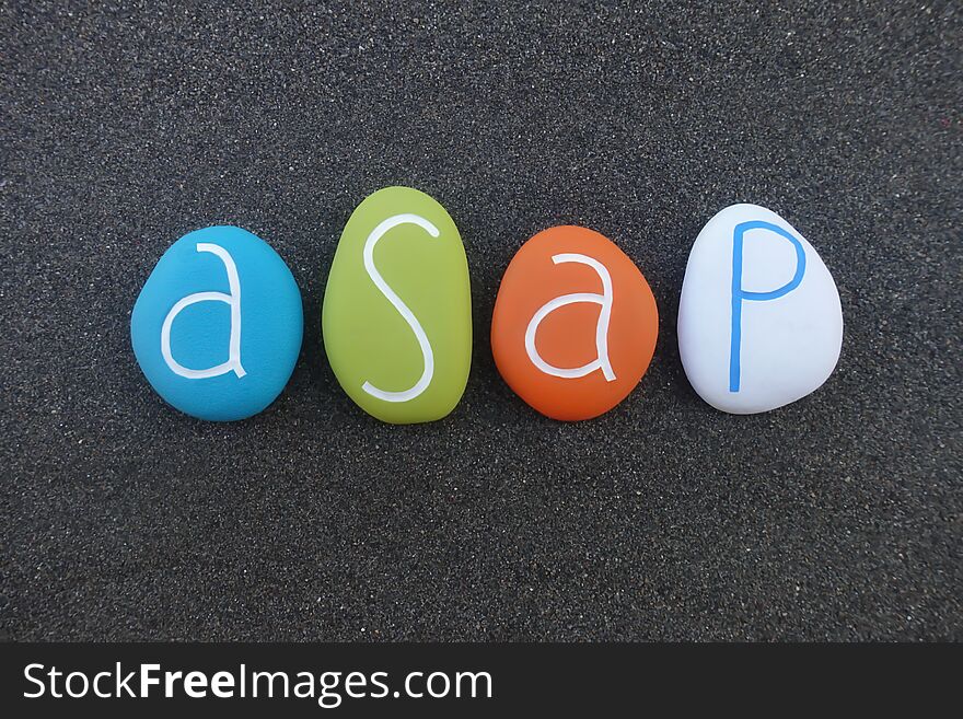 Asap, as soon as possible, acronym, composed with multi colored sea stones over black volcanic sand
