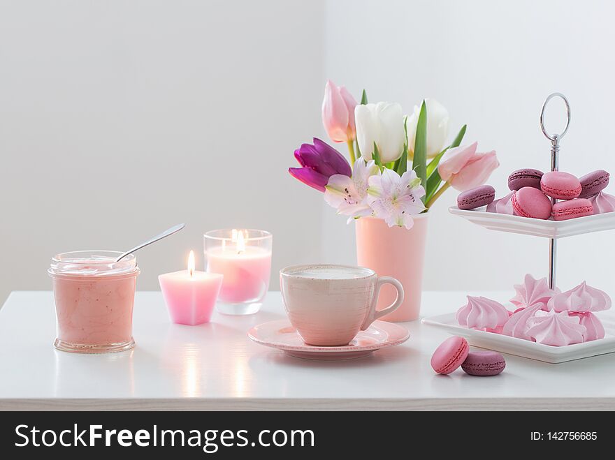 Tulips in vase and cup of coffee with dessert