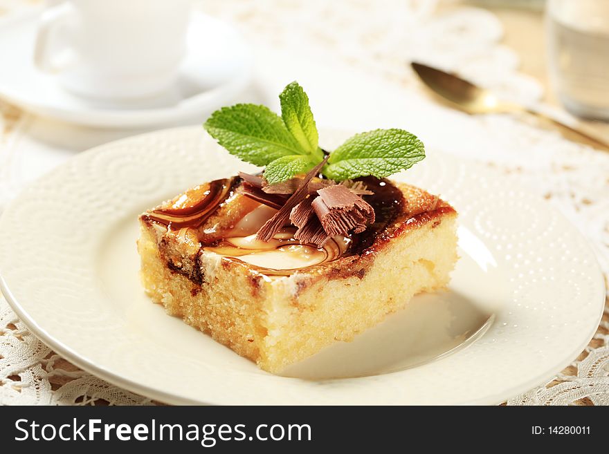 Slice of sponge cake topped with curd and chocolate syrup