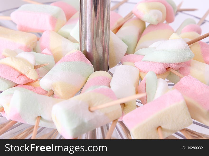 Many snacks of different colored marshmallows.Background