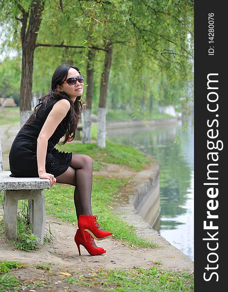 Asian woman sit in Chair with  High-heeled shoes.