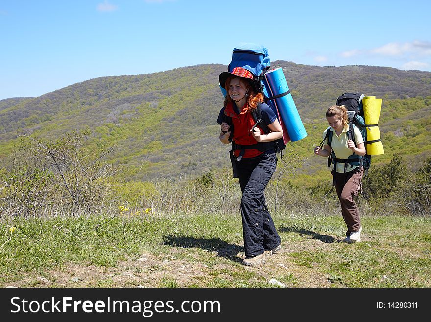 Hiker girl with backpack walking in mountains. Hiker girl with backpack walking in mountains
